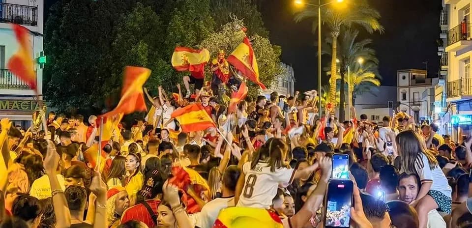 Crowd celebrating with flags at night