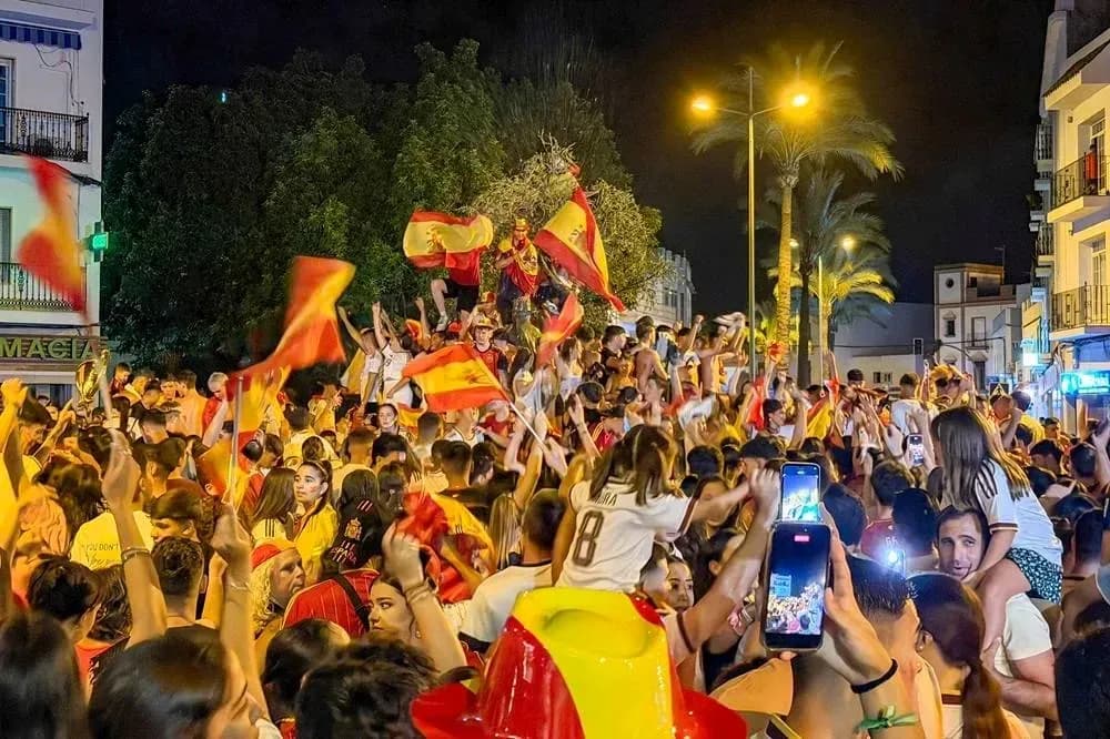 Crowd celebrating with flags at night