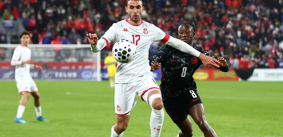 Tunisian player controlling the ball against opponent