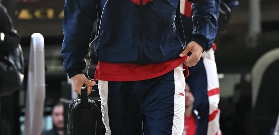 Player in tracksuit arriving at team bus
