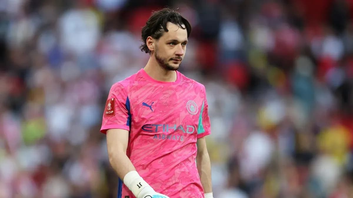 Goalkeeper in pink kit walking on the pitch