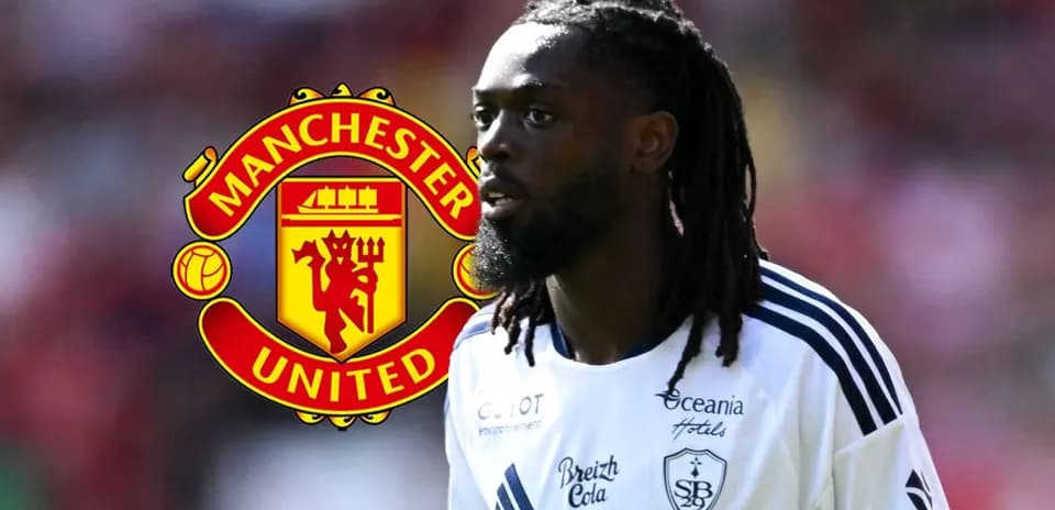 Player in white kit with Manchester United logo background