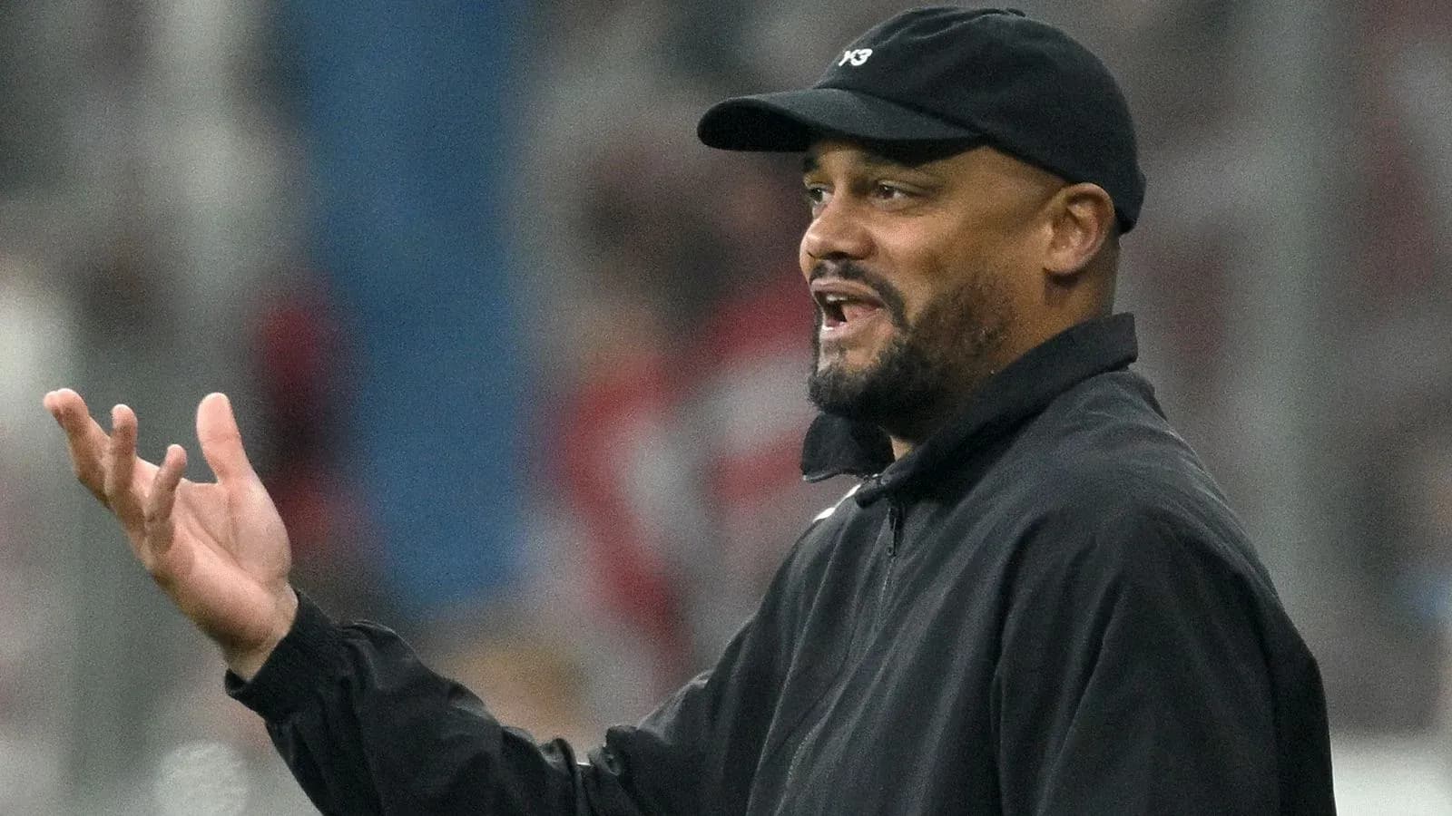 Coach gesturing during a football match on the sidelines