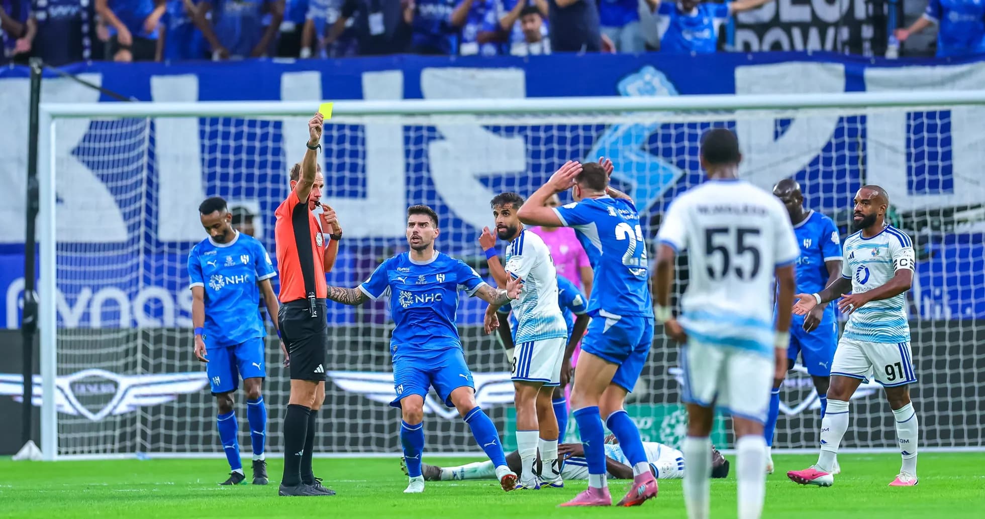 Referee showing yellow card during football match