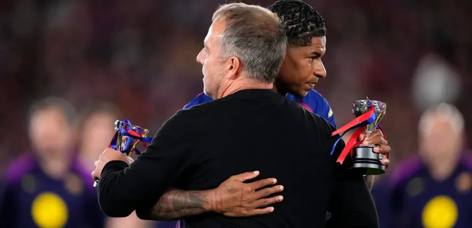 Coach embracing player holding trophy after match