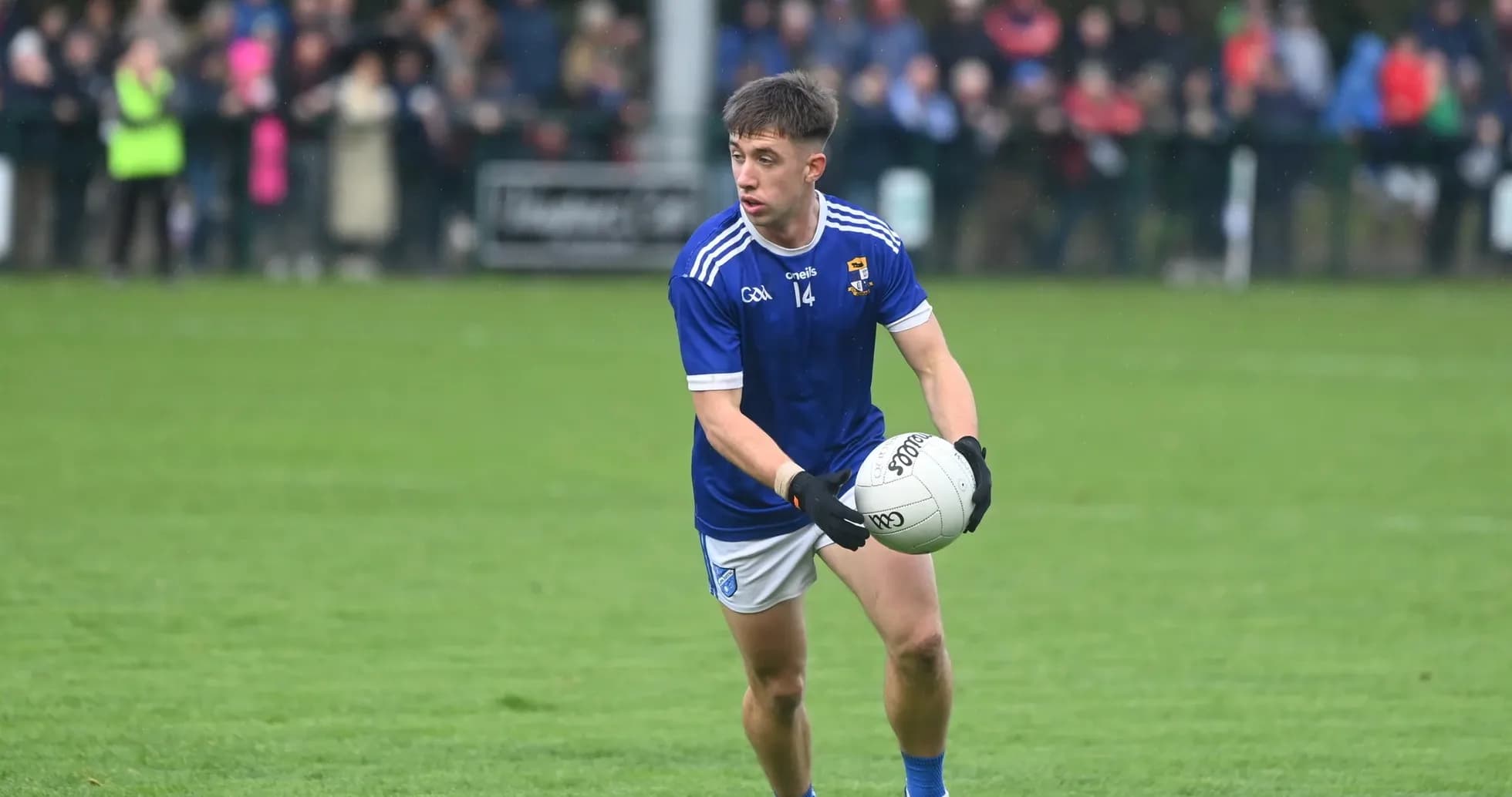 Player in blue kit holding a Gaelic football