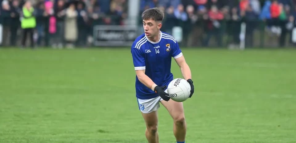 Player in blue kit holding a Gaelic football