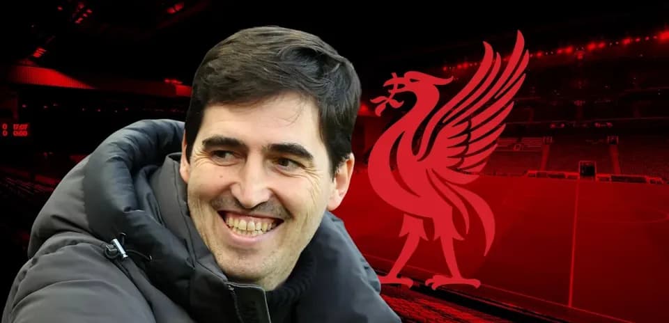 Coach smiling in front of Liverpool stadium backdrop