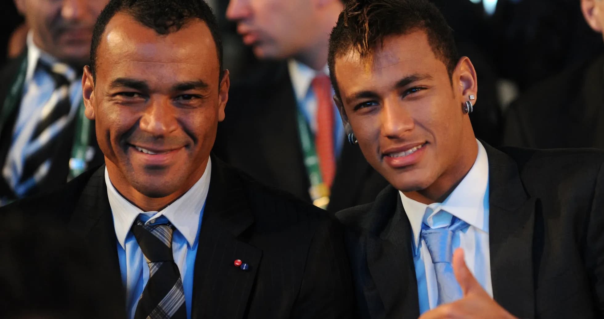 Two men in suits smiling at an event