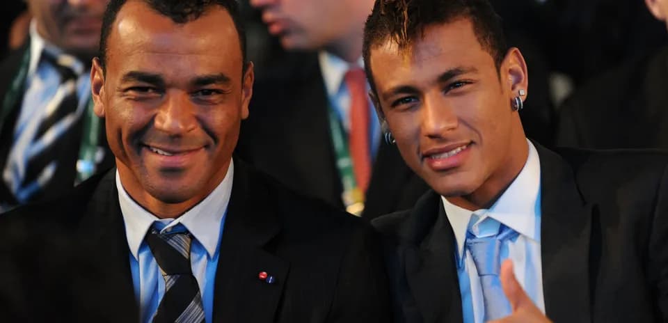 Two men in suits smiling at an event