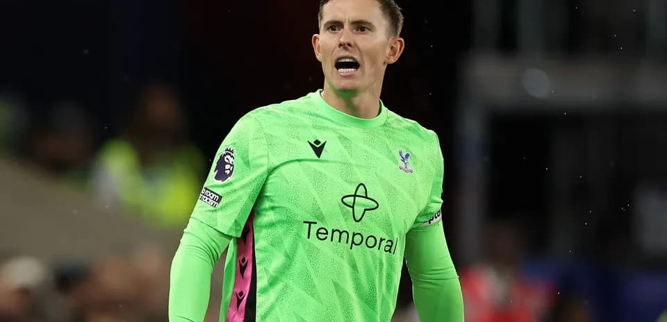 Goalkeeper in green kit directing play on field