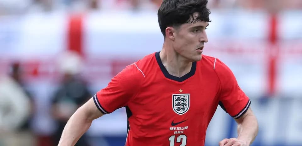Player in red England kit running on the field