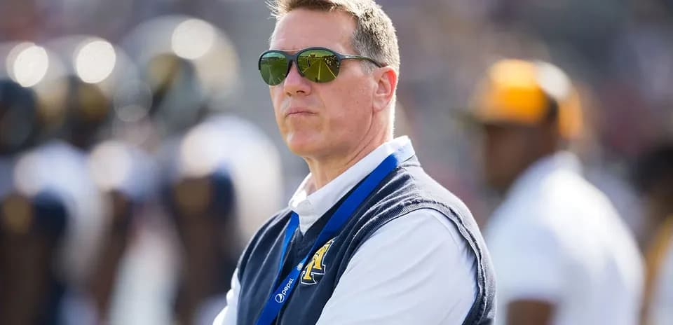 Man wearing sunglasses observing the football field