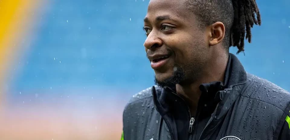 Player in Celtic FC jacket during rainy day