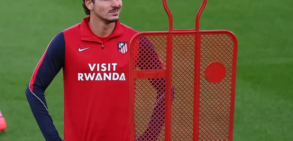 Player standing beside training dummy on pitch