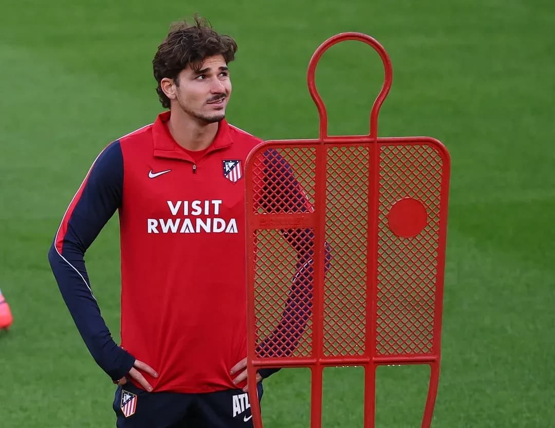 Player standing beside training dummy on pitch