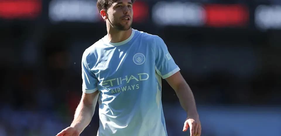 Player in light blue jersey walking on pitch