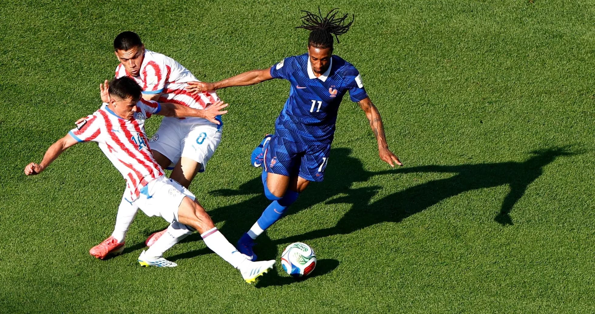 Paraguay and France players competing for the ball