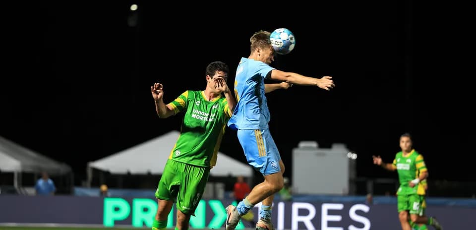 Player jumping to head the ball during match
