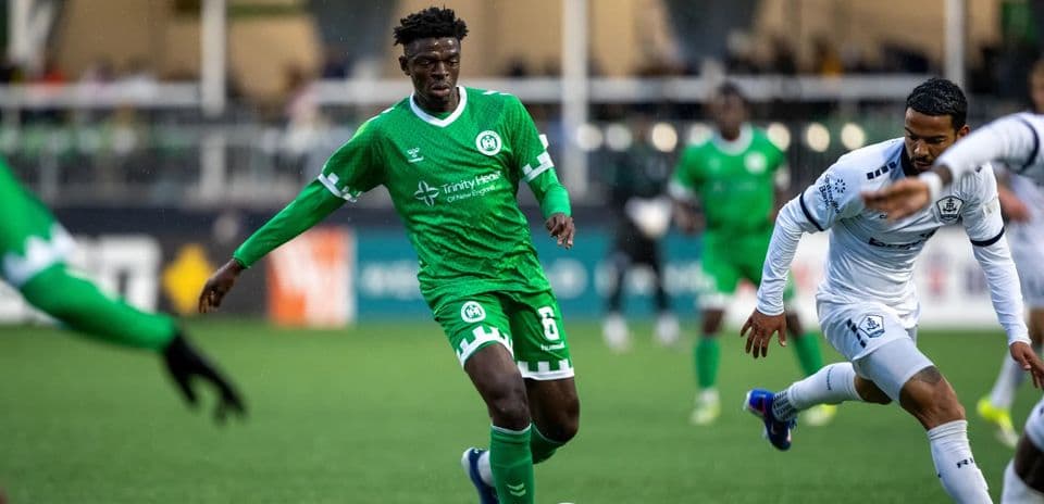 Player in green jersey dribbling the ball