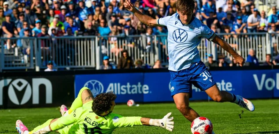 Player scoring against goalkeeper during match