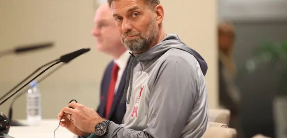 Manager seated at press conference table with microphone