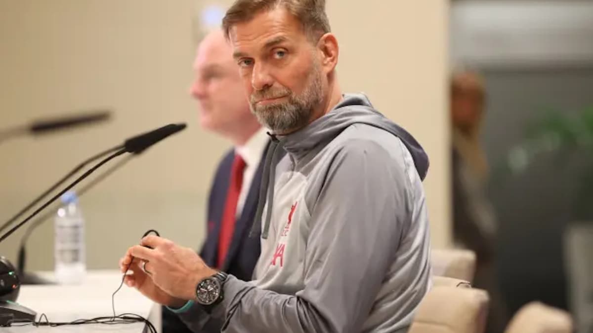 Manager seated at press conference table with microphone