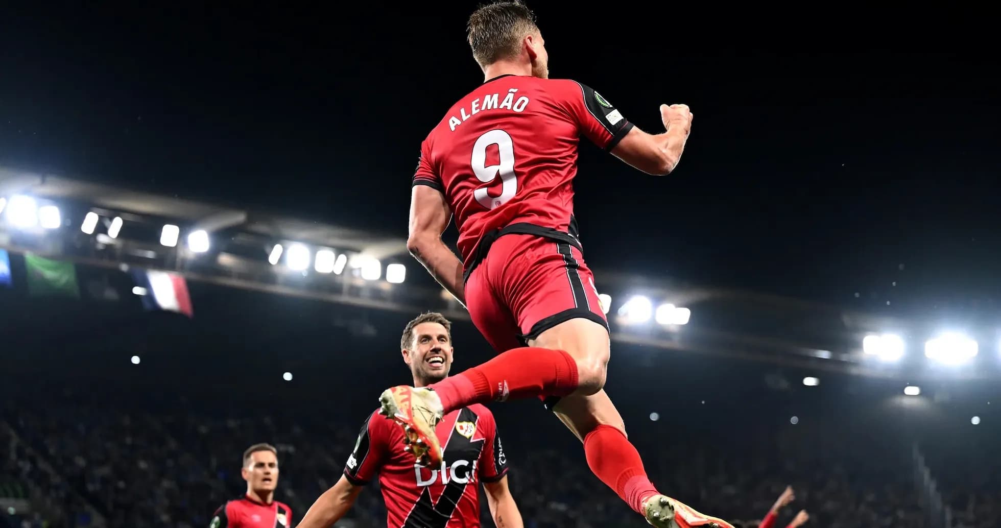 Player celebrating a goal with teammates on field