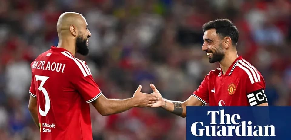 Two Manchester United players exchanging greetings on field
