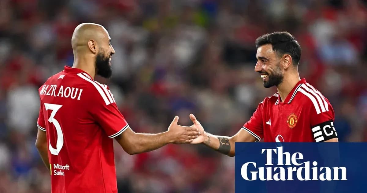 Two Manchester United players exchanging greetings on field