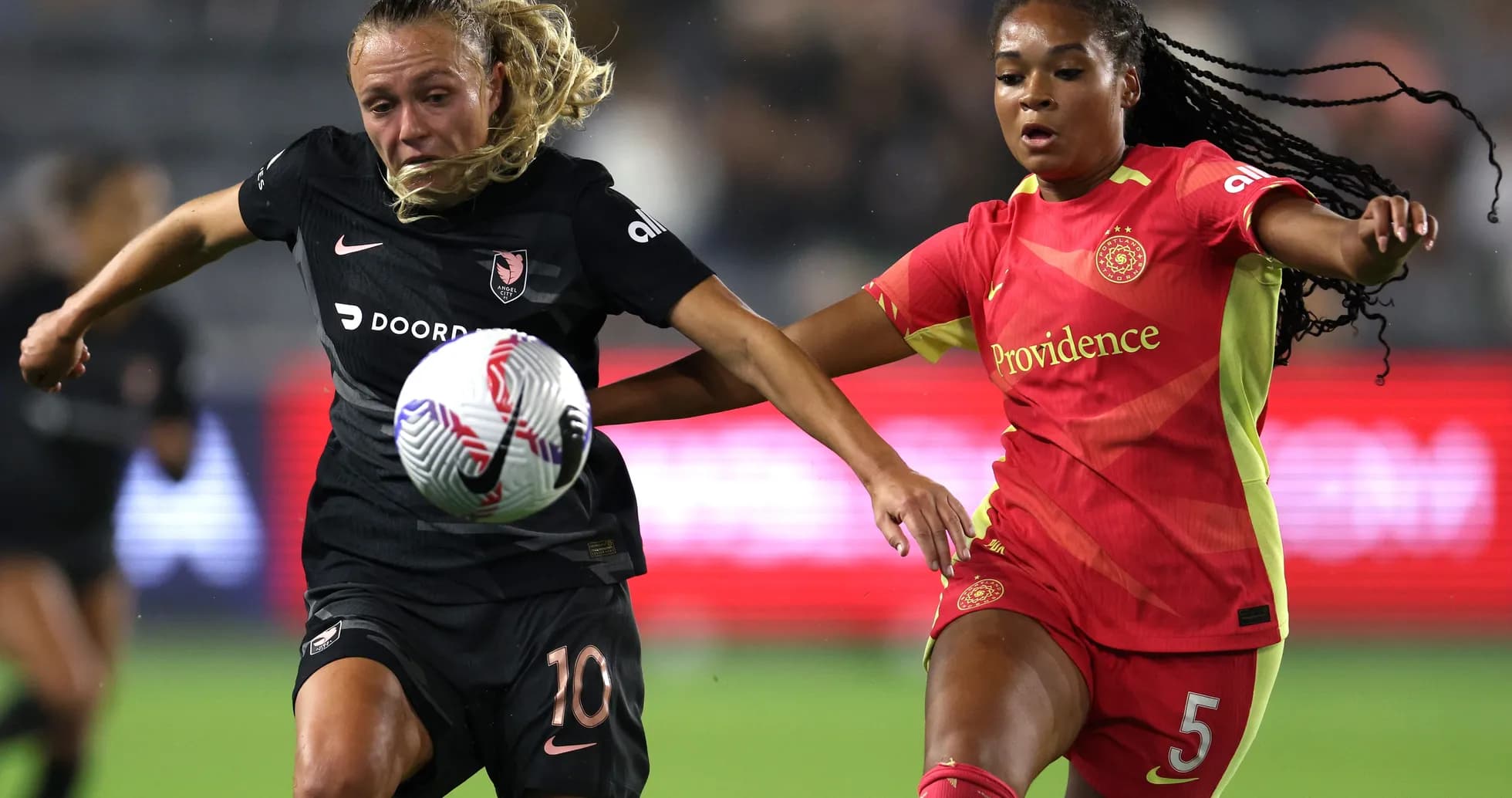 Players competing for the ball in NWSL match