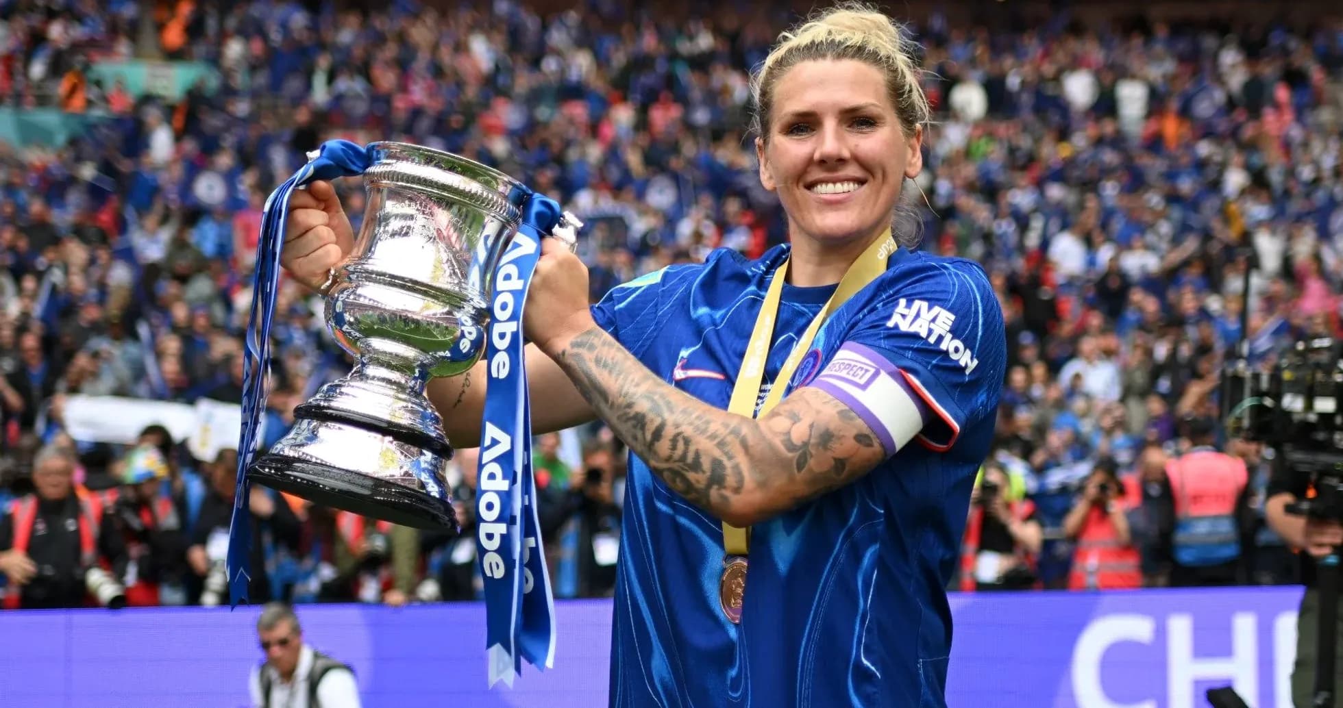 Player celebrating with trophy in stadium crowd