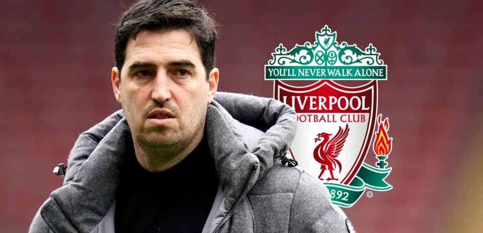 Coach standing in front of Liverpool FC logo