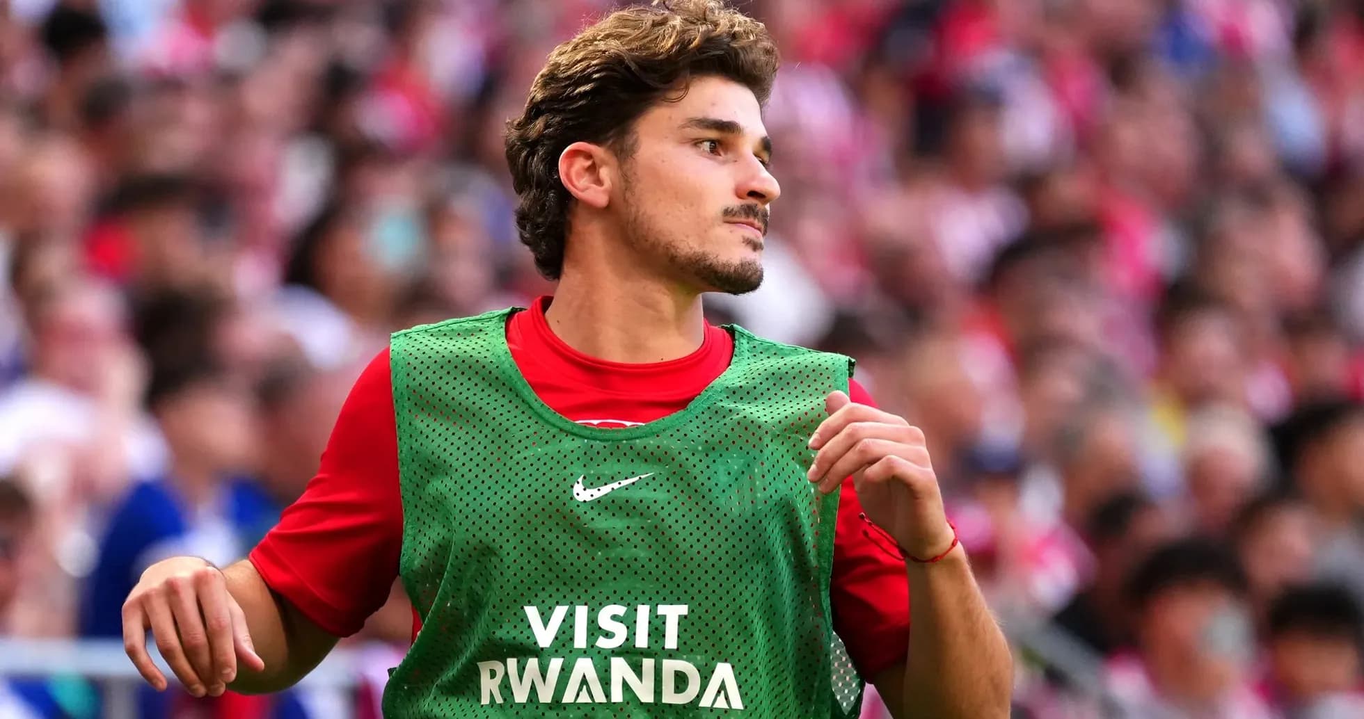 Player in training bib on sidelines during match