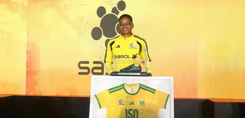 Athlete posing with award and jersey at event
