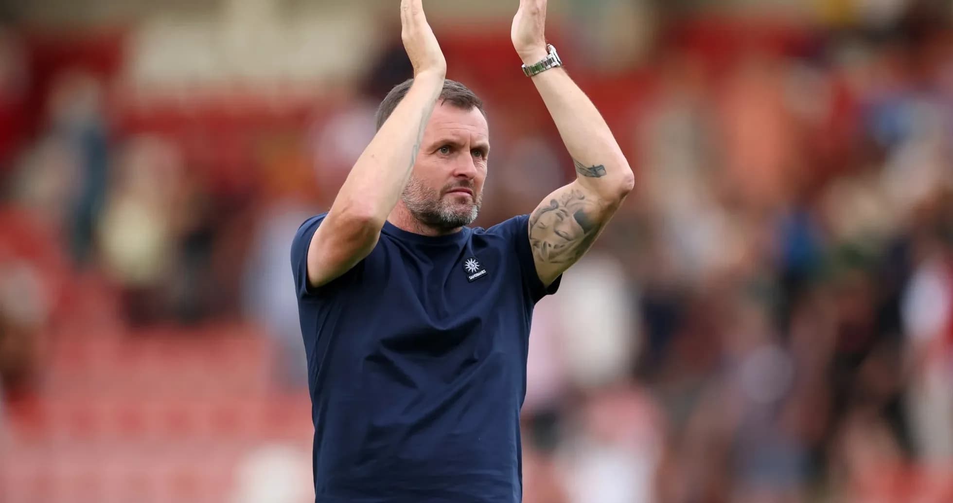 Coach applauding fans after match conclusion