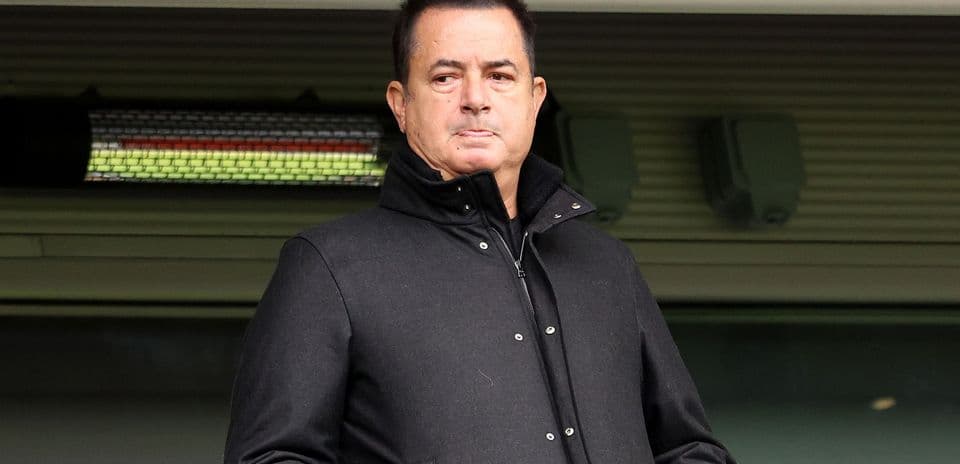 Man in black coat observing from the stands