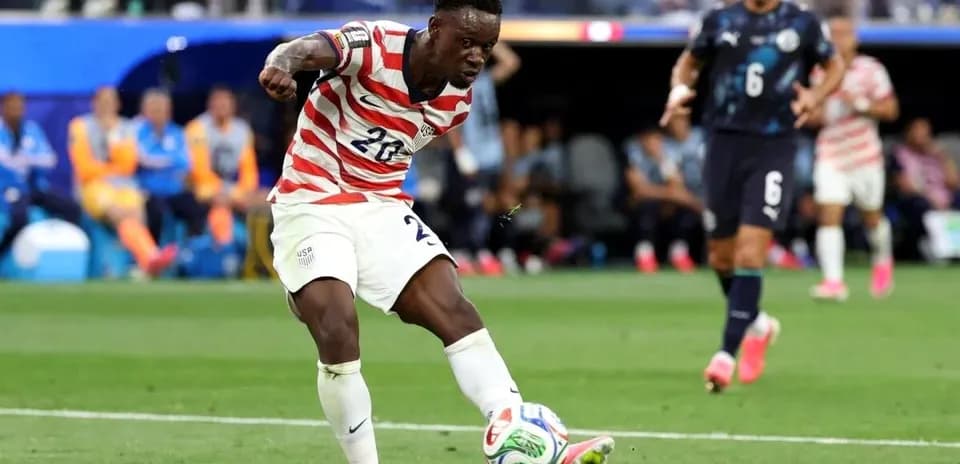 Player in USA kit kicking soccer ball during match