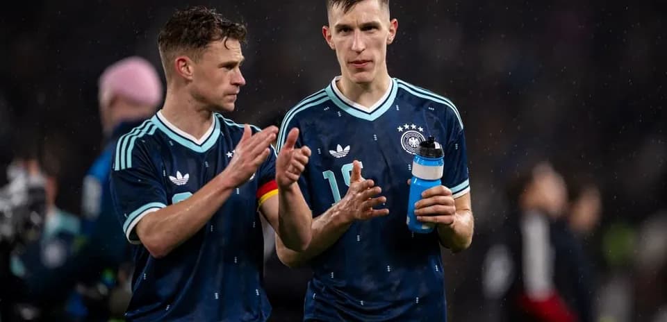 Two German players walking off the field post-match
