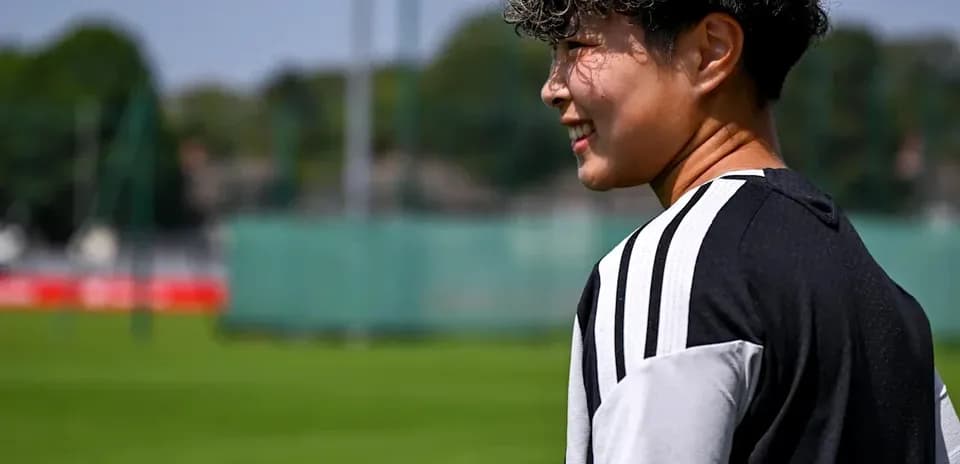 Player walking on training pitch in sunlight