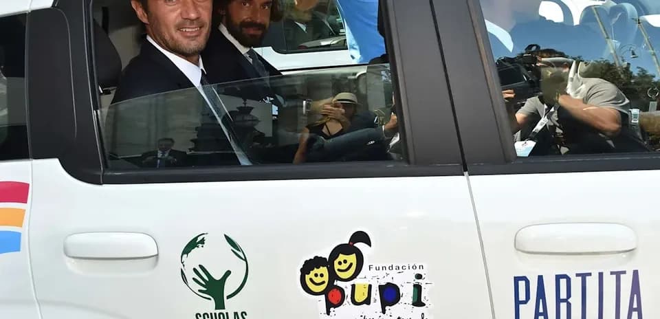 Two men in a car with charity logos