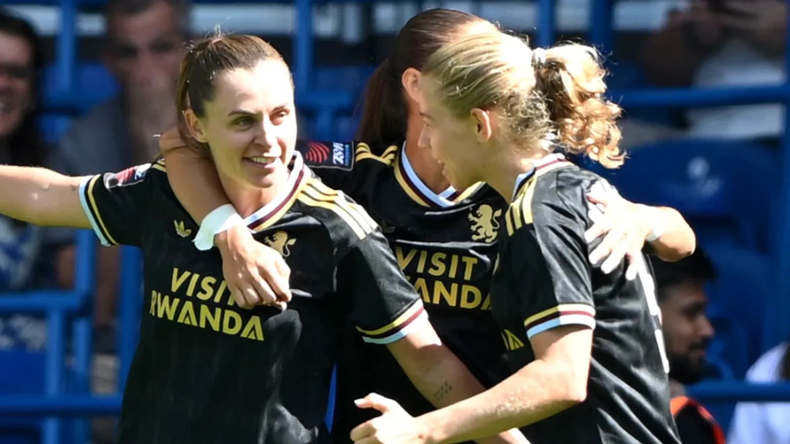 Three players celebrating a goal on the field