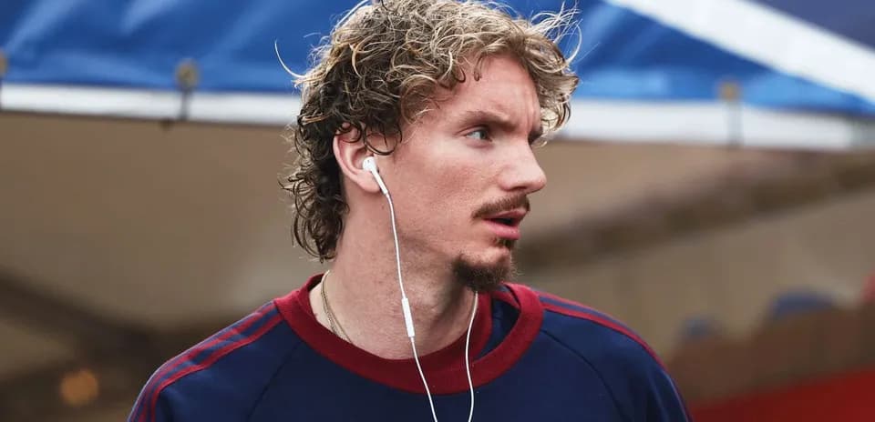 Athlete wearing earbuds, walking in casual attire