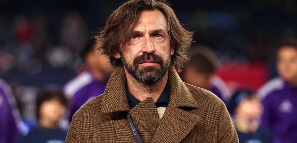 Man in brown coat standing on the sidelines