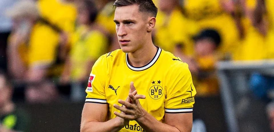 Player in yellow jersey applauding fans at stadium