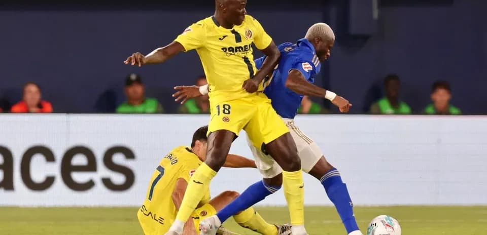 Villarreal player challenging Oviedo opponent for ball