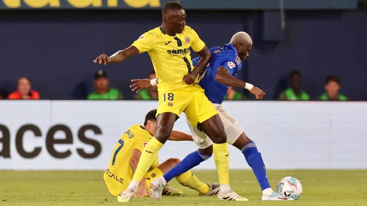 Villarreal player challenging Oviedo opponent for ball