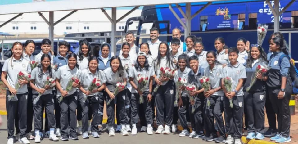 Women's sports team posing with flowers at venue