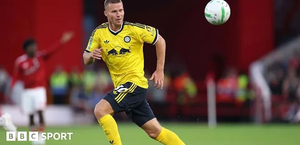Player in yellow kit chasing a flying ball
