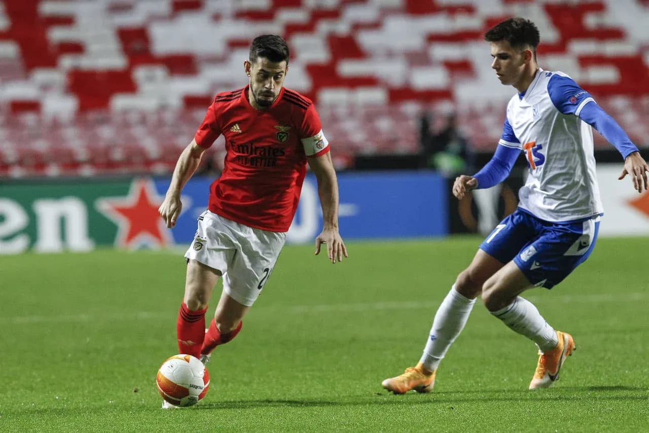 Benfica player dribbling against Lech Poznan